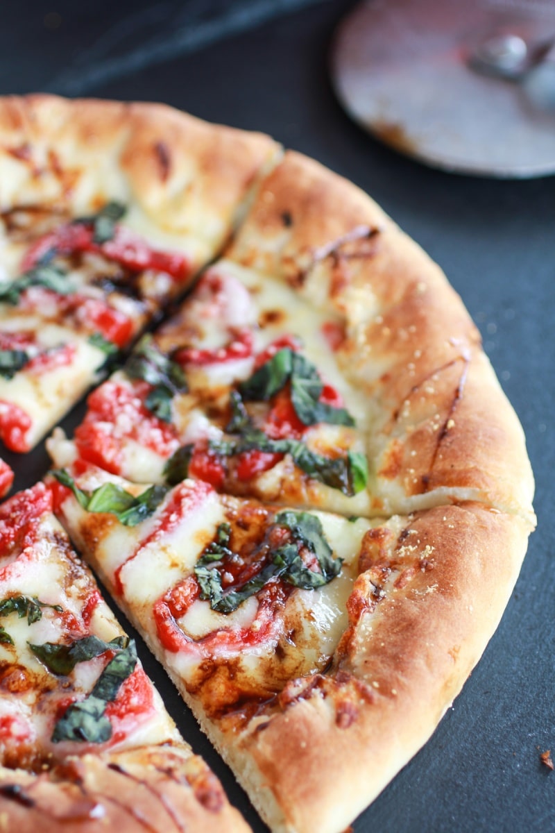 green olive pesto pizza with roasted red peppers and feta stuffed crust