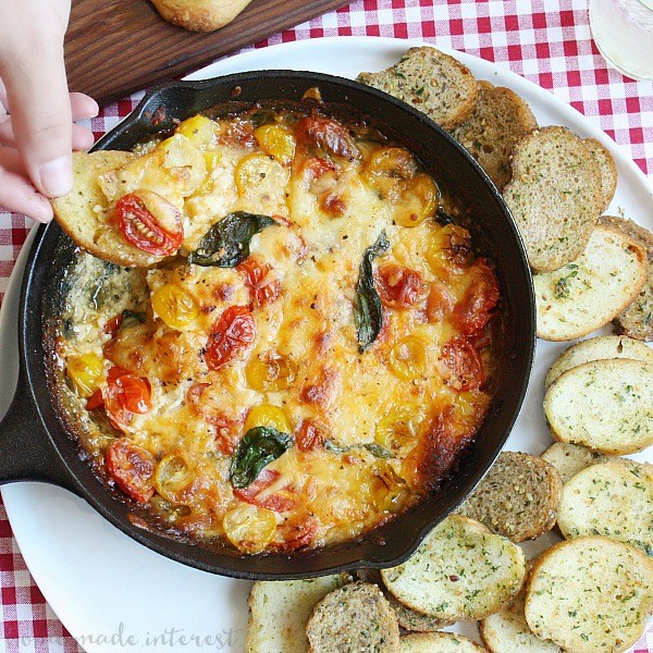 caprese dip in cast iron skillet served with bread